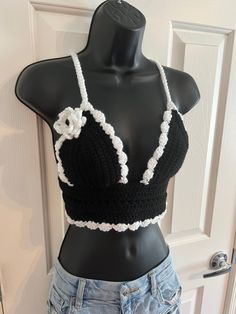 Schitt's Creek Moira Rose inspired crochet black and white crop top with decorative flower piece! Such a perfect top for a music festival, farmers market, concert, food festival or just a stunning piece for the boho, Schitt's Creek Moira Rose fan. Black and White colors are a brilliant combination to honor such an amazing character in television; with a fabulous crocheted flower accent.  Shirt is not lined but tight crochet pattern allows for little to no show through. Such a gorgeous, one of a kind shirt, perfect to stand out in a crowd!  Criss-Cross tie is single crocheted for a comfortable fit around the body. Tie is adjustable for perfect fit for sixes XS to Large, cup size was made to accommodate AA to D size. Larger cup size will show more cleavage.  Torso Band is approx. 24 inches; Fitted Crochet Trim Party Top, Fitted Crochet Trim Top For Party, Fitted Crochet Crop Top For Party, Crochet Top Alternative, Concert Crochet Top, Fitted Cotton Crochet Lace Crop Top, Fitted Crochet Trim Crop Top, Fitted Black Top With Crochet Lace, White Fitted Crochet Lace Crop Top