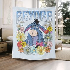 eeyore surrounded by flowers and daisies on a blue background with the word eeyore