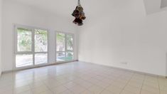 an empty room with tile floors and large windows