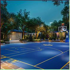 an outdoor basketball court is lit up at night with trees and bushes in the background