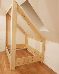 an attic bedroom with wooden flooring and white walls is pictured in this image from the bottom level