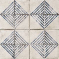 a white and blue tiled wall with diagonal designs on it's sides, all in different sizes