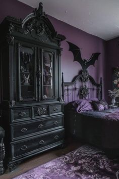 a bedroom decorated in purple and black with bats on the wall above the dressers