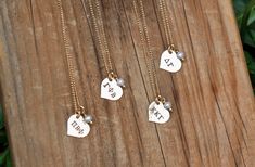 three personalized necklaces on a wooden table