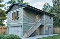 a two story house with stairs leading up to the garage