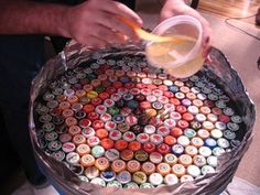 a man is making a cake made out of beer bottle caps