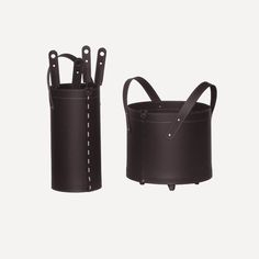 two black leather buckets with handles and straps on each side, one is empty