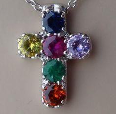 "This 18k white gold cross pendant measurements are 13 mm height 9.75 mm wide set with 6 natural colored stones. The stones are one blue sapphire, ruby, emerald , orange sapphire, yellow sapphire and pink sapphire all the stones are natural and have excellent clarity. The 14k white gold chain in made in Italy and can be made 16,17 or 18 inch long just let us know. We are also able to do custom orders with a variety of gemstones. We are also able to make it in yellow or rose gold for the same pri Multicolor Hallmarked Necklace For Gift, Multicolor Hallmarked Necklaces As Gift, White Gold Multi-stone Jewelry Gift, White Gold Multi-stone Jewelry For Gift, Multicolor Hallmarked Necklace For Anniversary, Luxury Multicolor Birthstone Jewelry, Multicolor Hallmarked Jewelry For Gifts, Cubic Zirconia Multi-stone Gemstones For Gifts, Multicolor Round Jewelry With Polished Finish