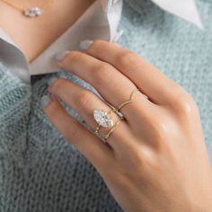 a woman's hand with two rings on her fingers and one ring in the middle