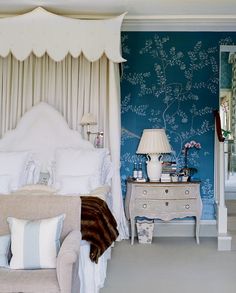 a bedroom with blue walls and white furniture