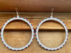 Say hello to these big beautiful white Christmas themed hoops! Hand beaded with premium white, red, green, and blue Miyuki delica glass seed beads stitched with premium Miyuki nylon threads onto a stainless steel bezel circle. Attached to a pair of sterling silver fish hook ear wires. Large, lightweight and hypoallergenic. Traditional White Hoop Earrings, Festive White Earrings With Colorful Beads, Festive White Beaded Earrings, Festive White Round Beaded Earrings, White Hoop Earrings With Tiny Beads, White Tiny Beaded Small Hoop Earrings, White Tiny Beads Small Hoop Earrings, White Small Hoop Beaded Earrings With Tiny Beads, White Tiny Beaded Round Earrings