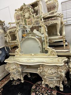 an ornate white vanity with mirror and other antique furniture