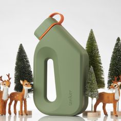 several toy deer stand in front of a green object