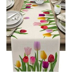 an image of a table setting with tulips painted on the table runner and place settings