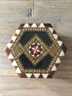 a wooden box sitting on top of a wooden table next to a brown and white wall