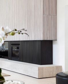 a living room filled with furniture and a fire place next to a wall mounted tv