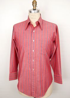 "\"The Jim Dandy\" vintage 1970s (to late 1960s) shirt by historic men's shirtmaker Arrow (the Kent Collection) in charming red with blue double-stripe pattern, white buttons, and subtle white stitching, featuring nice lightweight \"Perma-Iron\" cotton blend fabric and very 70s-chic, longer pointed collar--Beautiful condition! SIZE: Tagged 15.5\"/32\" Neck/Sleeve (Men's Medium) MEASUREMENTS*: Shoulder: 18\" Chest (underarm to underarm): 23\" Waist: 20\" Length (base of back collar to back hem): Red Long Sleeve Shirt With Vertical Stripes, Classic Collared Yarn-dyed Shirt, Classic Yarn-dyed Collared Shirt, Red Cotton Shirt With Vertical Stripes, Red Shirt With Striped Collar For Spring, Vintage Cotton Shirt With Striped Collar, Vintage Red Shirt For Spring, Retro Red Cotton Shirt, Vintage Pink Shirt With Buttons