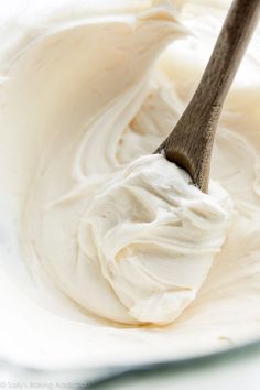 a wooden spoon with white whipped cream in it