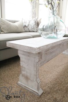 a coffee table with a glass vase on top