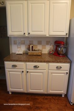 a kitchen with white cabinets and granite counter tops