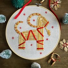 an embroidery pattern with a dog on it and other decorations around it, including ornaments