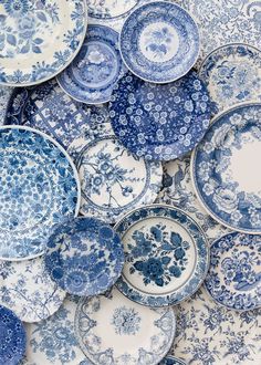 many blue and white plates are stacked on top of each other in the same pattern