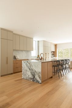 Ateliers Jacob contemporary kitchen with a marble island Column On Kitchen Island, Oak Cabinets Oak Floor, Marble And Oak Kitchen, Kitchen Oak Flooring, Kitchen Island Oak, Kitchen Wallpaper Design, Modern Oak Kitchen, Kitchen Wallpaper Ideas, Welcoming Kitchen