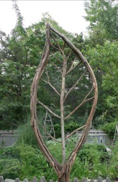 a wooden sculpture in the middle of a garden