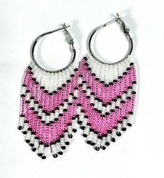 These awesome fringe earrings are sure to make you pretty in pink! They have pretty, shiny pink beads, accented by black beads, on a background of white beads. The black beads really make the pink pop! The glass seed beads are hung on a 1" silver plated hoop, making the earring length approx. 2 3/4" long and 1" wide. The earring closure is a lever back style. These are great for casual wear, as well as for gifts. They make a nice gift for a friend or family member. Nice for birthdays, graduation Pink Hoop Earrings With Dangling Beads For Gift, Pink Beaded Fringe Earrings With Round Beads, Pink Dangle Beaded Earrings With Black Beads, Pink Beaded Earrings With Fringe, Pink Jewelry With Black Beads For Gift, Pink Beaded Earrings With Black Beads For Gift, Pink Beaded Earrings With Round Beads For Pierced Ears, Pink Beaded Fringe Earrings For Party, Pink Beaded Chandelier Earrings