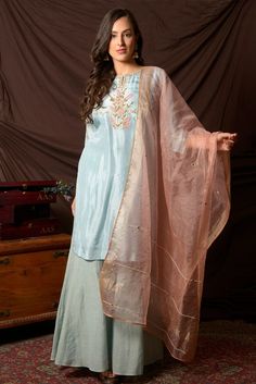 Attractive sky blue gota embroidery chanderi suit with palazzo and pink dupatta. The suit is enhanced with beautiful gota patti and anchor work on the neckline. Shop designer Indian suits in USA from Pure Elegance. Disclaimer: The actual product may vary slightly from the image. These are custom orders, hence expect slight variation in color, placement of the motif or buta. ESTIMATED DELIVERYBecause this is a custom order, it would take about 4-6 weeks from the date of purchase. RETURN POLICYThis product is a custom order and cannot be returned or exchanged. Suit With Pink Dupatta, Designer Indian Suits, Gota Embroidery, Chanderi Suit, Pink Dupatta, Indian Clothing Store, Chanderi Suits, Indian Designer Suits, Indian Suits