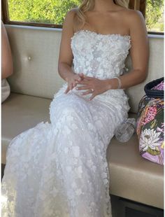 a woman in a white dress sitting on a couch