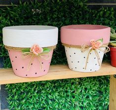 three flower pots sitting on top of a wooden shelf