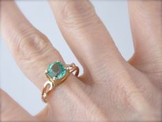 This is a beautiful vintage ring, a solitaire that is as lovely as it is versatile! Simple sweeps of gold grace the shoulders, providing a perfect balance to the gorgeous center stone! We've set a Colombian Emerald in this ring, a bright green gem with unbelievable shine! Incredibly clear and filled with light, this emerald is of exceptional quality, a one of a kind stone from our collection of Colombian gems that we're proud to offer! Metal: 14K Yellow and Rose Gold Gem: Emerald 1.56 Carat Gem Classic Emerald Ring With Accent Stones And Round Band, Classic Emerald Ring With Accent Stones, Promise Solitaire Emerald Ring With Round Cut, Elegant Emerald Solitaire Ring With Round Band, Elegant Solitaire Emerald Ring With Round Band, Heirloom Style Round Emerald Promise Ring, Emerald Solitaire Ring For Anniversary, Classic Emerald Wedding Ring With Round Stone, Formal Rose Gold Solitaire Emerald Ring