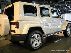 a white jeep is on display at an auto show