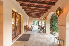 an outdoor covered walkway with chairs and lamps