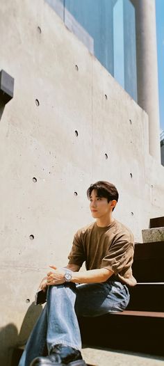 a young man sitting on some steps in front of a building