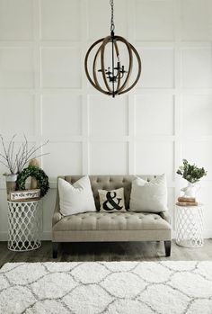 a living room filled with furniture and a chandelier hanging from the ceiling above it