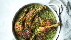 a white bowl filled with chicken and green sauce