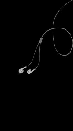 a pair of ear buds connected to a cord on a black background with space for text