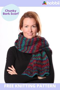 a woman with her arms crossed wearing a multicolored knitted cowl scarf