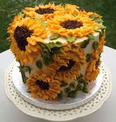 a cake decorated with sunflowers on top of a table