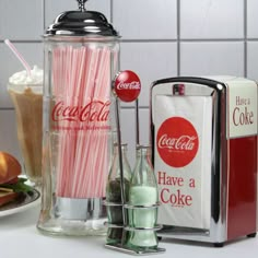 there is a coca - cola machine and some drinks on the counter next to it