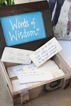 a wooden box filled with lots of writing on top of a white table next to a blue sign