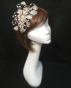 Delicate silver beige fascinator perfect for the guest who wants something fairly understated. This design is a beautiful selection of glass effect leaves and flowers clustered together and set onto a fine comfort base tiara band. As with all our designs, this piece can be made exact to the image or in any colour combination to match in with your outfit. If a specific colour is required customers can message over an image of their outfit and accessories, or if time allows customers are always we Beige Hair Accessories For Wedding, Cream Headpiece With Pinched Crown For Evening, Silver Bridal Headband For Party, Beige Wedding Headband, Adjustable Silver Fascinator For Wedding, Elegant Silver Fascinator For Wedding, Adjustable Silver Headband Fascinator, Elegant Silver Wedding Fascinator, Elegant Silver Bridal Headband