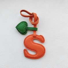 an orange and green keychain with the letter s on it's side