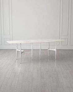 a white table sitting on top of a hard wood floor next to a white wall