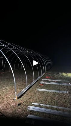 a row of metal poles sitting on top of a grass covered field