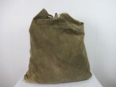 "Vintage 1940s duffel bag, large laundry bag. Made of green-gray canvas. Has copper grommets and rope drawstring. Black stencil: Property of Chicago Towel Co. 2516 SO. Wabash Ave. No label. Measures 27.5\" wide and 30.5\" tall. In very good condition with a worn hole near bottom(photo)." Vintage Khaki Cotton Bags, Vintage Green Cotton Bag, Black Stencil, Vintage Bandana, Scandinavian Chairs, Workwear Vintage, Carhartt Workwear, 1970s Dresses, Vintage Luggage