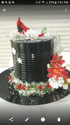 a black cake decorated with poinsettis and greenery