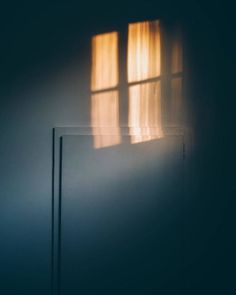 the light is shining through two windows in an empty room